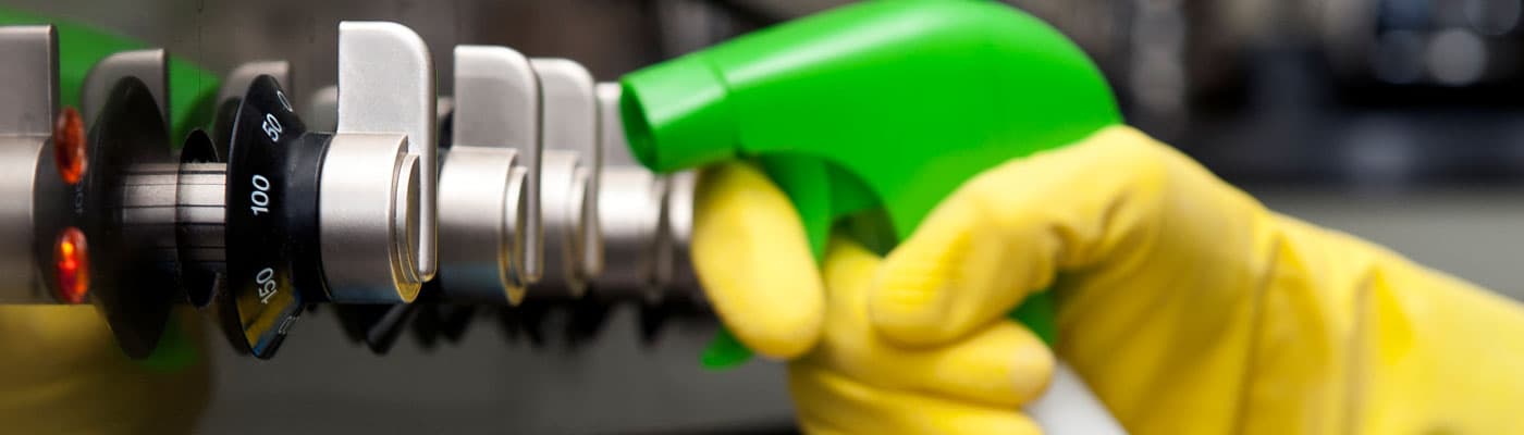 Technician cleaning a cooker with eco-friendly spray